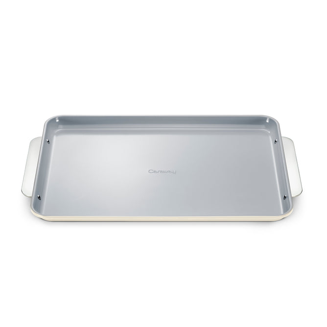 The Caraway Large Ceramic Baking Sheet features a non-toxic, gray ceramic coating with raised edges for even baking. Its two wide handles ensure easy handling, making it convenient and oven-safe.