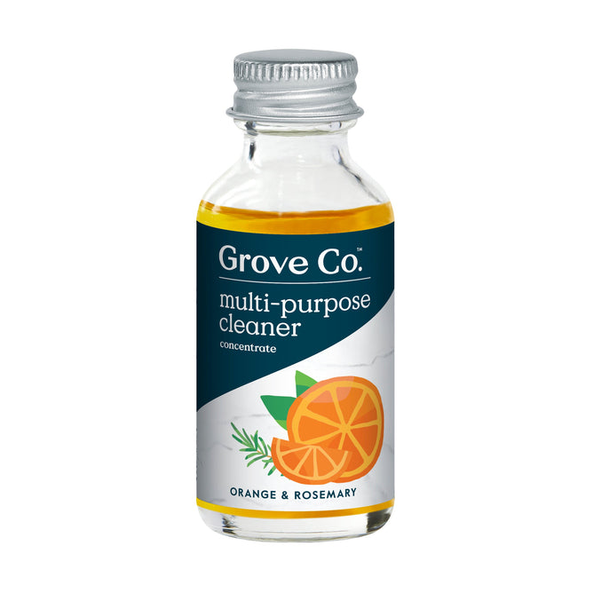 A small transparent bottle with a silver cap holds a golden, plastic-free liquid labeled Grove Co. Multi-Purpose Cleaner Concentrate, featuring orange and rosemary illustrations and boasting an Orange & Rosemary natural fragrance.
