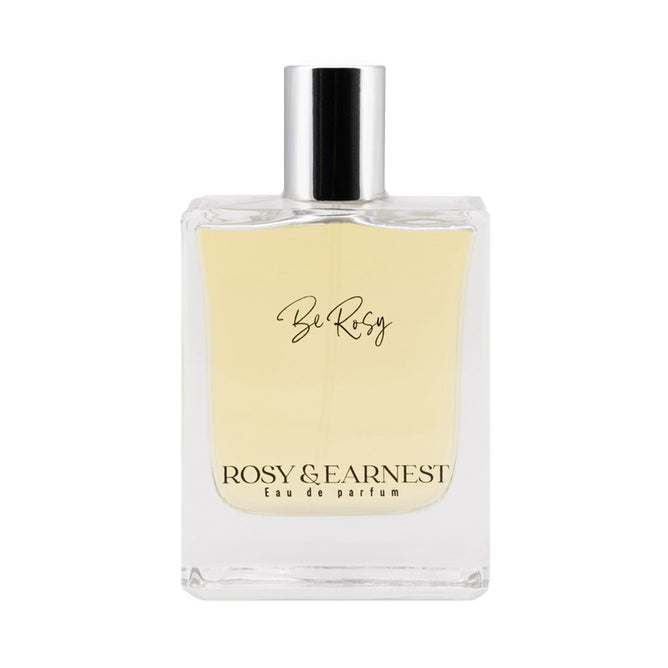 The Be Rosy Eau de Parfum by Rosy & Earnest comes in a clear glass bottle with a silver cap, revealing the light golden fragrance. This EWG VERIFIED™ scent, crafted by a Master Perfumer, features a label with Be Rosy at the top and Rosy & Earnest Eau de Parfum at the bottom.