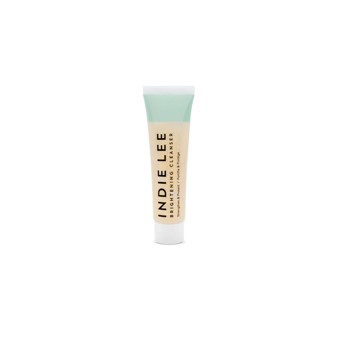 A tube of Indie Lee Brightening Cleanser - Sample, infused with Strawberry Seed Oil for luminous skin. The light-colored tube has a white cap and black text displaying the product name and brand, set against a plain white background.