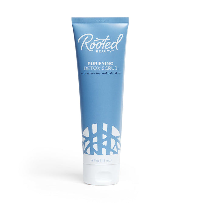 A 4 fl oz (118 ml) blue tube of Rooted Beauty Purifying Detox Scrub with white tea, calendula, and walnut shell powder for gentle exfoliation. It has a white cap, decorative pattern at the bottom, is EWG VERIFIED™, and features white text.