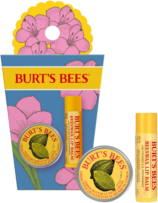 The Burts Bees Beeswax Lip Balm + Cuticle Cream Gift set includes a flower-adorned box with a moisturizing lip balm and cuticle cream in tins, featuring yellow honey-themed labels and made from natural origin ingredients.