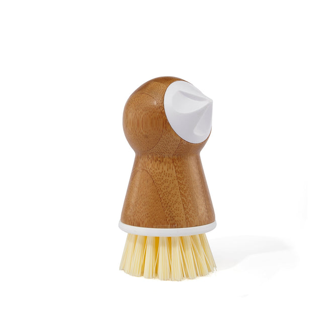 The Tater Mate by Full Circle is a wooden-handled scrub brush with stiff, light-colored bristles for meal preparation. It features a white sculpted grip for easy handling, ideal as a potato brush, and is perfectly showcased against a plain white background.
