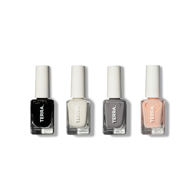 Four bottles of Terra Beauty Bars Classic Neutral Nail Collection are displayed with white caps, labeled TERRA. These vegan polishes offer long-lasting black, white, gray, and light pink hues against a plain white backdrop.