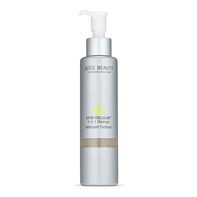 A silver bottle of Juice Beautys Stem Cellular 2-in-1 Cleanser featuring a pump dispenser has a label with a green droplet logo and The Organic Solution text, emphasizing its fruit stem cell infusion for rejuvenating care.