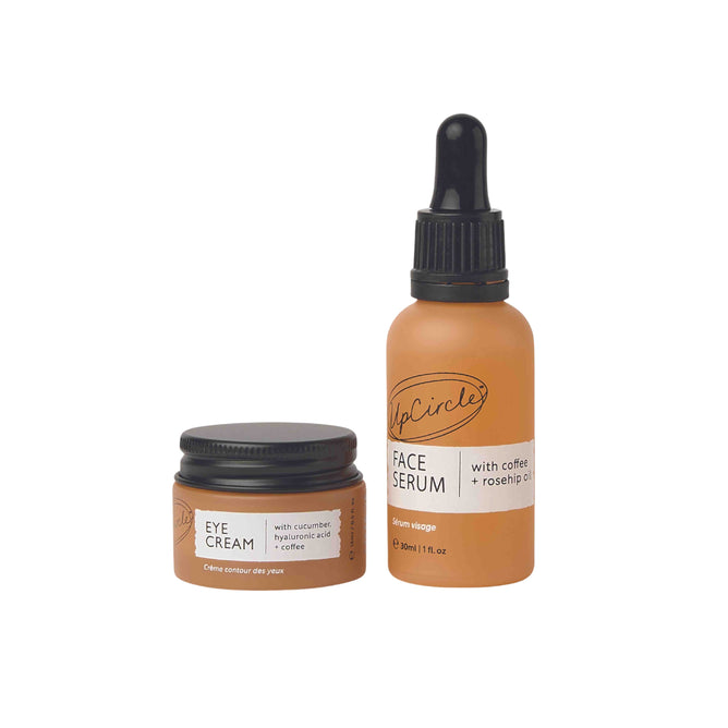 The Caffeinated Skincare Duo by UpCircle, featuring eye cream with cucumber, hyaluronic acid, upcycled coffee oil, and a face serum with coffee and rosehip oil for revitalized skin, stands with brown labels side by side.