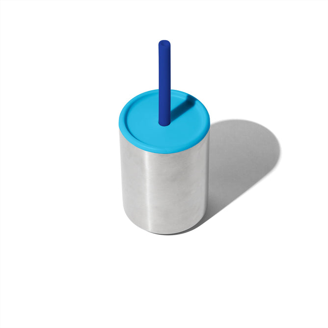 The Avanchy Training Stainless Steel Sippy Cup is a minimalist, eco-friendly cup featuring a vibrant blue lid and straw. Designed for 6+ months, it elegantly stands against a plain white background while keeping drinks at the ideal temperature.
