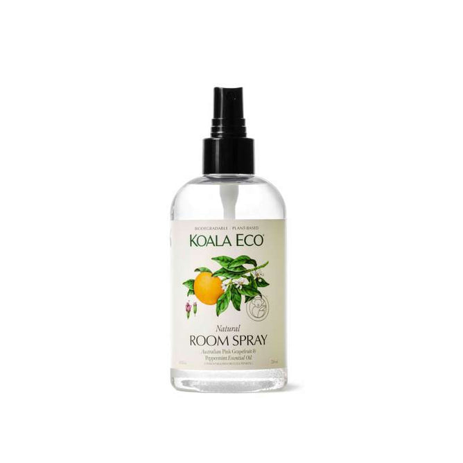 The Koala Eco Natural Room Spray features an illustrated lemon and leaves on a clear bottle, a black nozzle, and contains Australian essential oils such as tea tree, lemon, and peppermint. Its label highlights its biodegradable and plant-based properties.