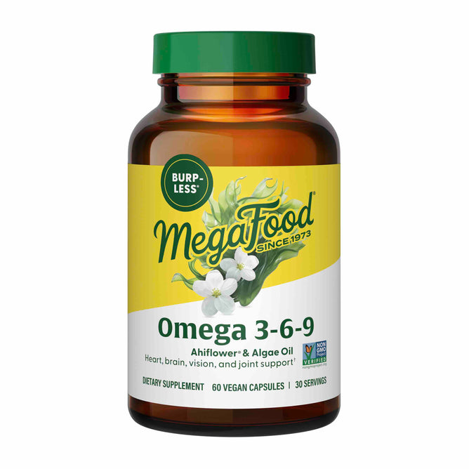A brown bottle of MegaFood Omega 3-6-9 features a yellow and green label with white flowers. This plant-powered formula supports heart, brain, vision, and joint health. It contains 60 vegan capsules designed to be burp-less for comfort.