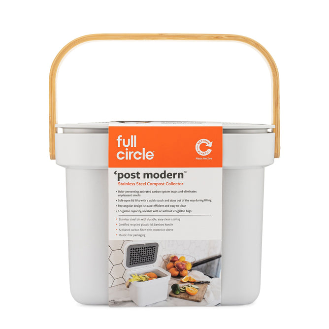 The Full Circle Post Modern Compost Bin, in white with a bamboo handle, displays images of fruits and vegetables. It includes an activated carbon filter for excellent odor prevention among other attractive features.