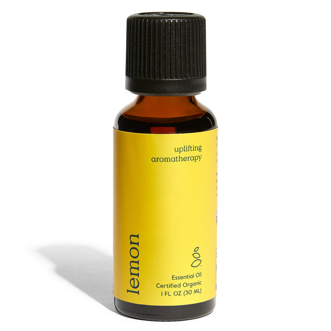 Grove Co.s Organic Lemon Essential Oil comes in a small amber 1 fl oz (30 ml) bottle with a black cap, featuring a yellow label marked uplifting aromatherapy and Certified Organic, ideal for space enhancement through its purifying properties.