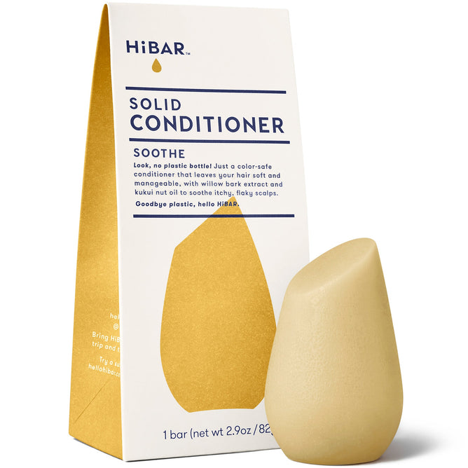 The HiBAR Soothe Conditioner Bar, a teardrop-shaped beige bar enriched with kukui nut oil, provides intense hair nourishment and comes in white packaging with gold accents featuring SOOTHE and Solid Conditioner.