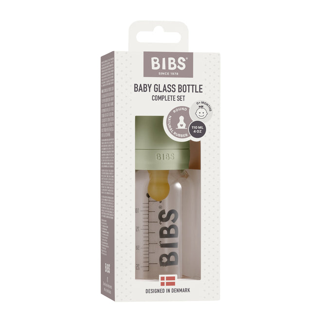 The BIBS Glass Baby Bottle Complete Set includes a 110 ml bottle with an anti-colic natural rubber nipple, packaged in a box patterned with beige dots that showcases product details and highlights its Danish design.