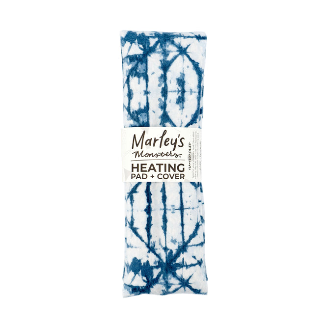 A blue and white tie-dye rectangular heating pad, labeled Marleys Monsters Flax Seed Heating Pad with Cover, is crafted to be flaxseed-filled for optimal comfort and is entirely plastic-free.