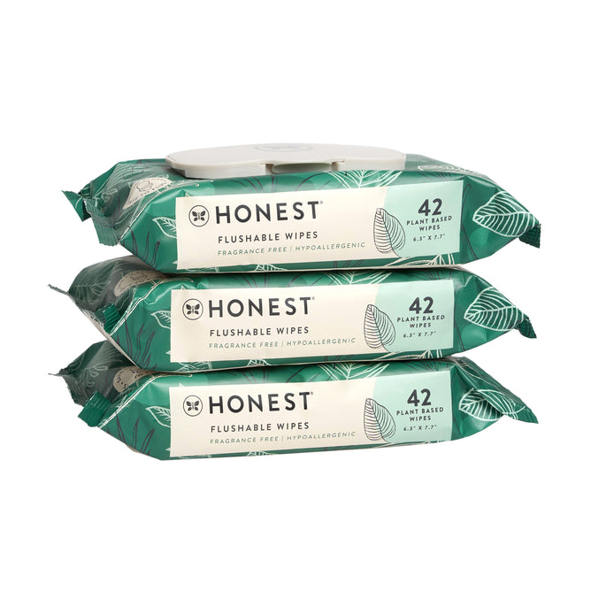 Three packs of The Honest Companys Flushable Wipes, 99% Water are neatly stacked. Each green pack with a leaf design is labeled 42 Plant-Based Wipes. These hypoallergenic wipes are fragrance-free and pH balanced for sensitive skin.