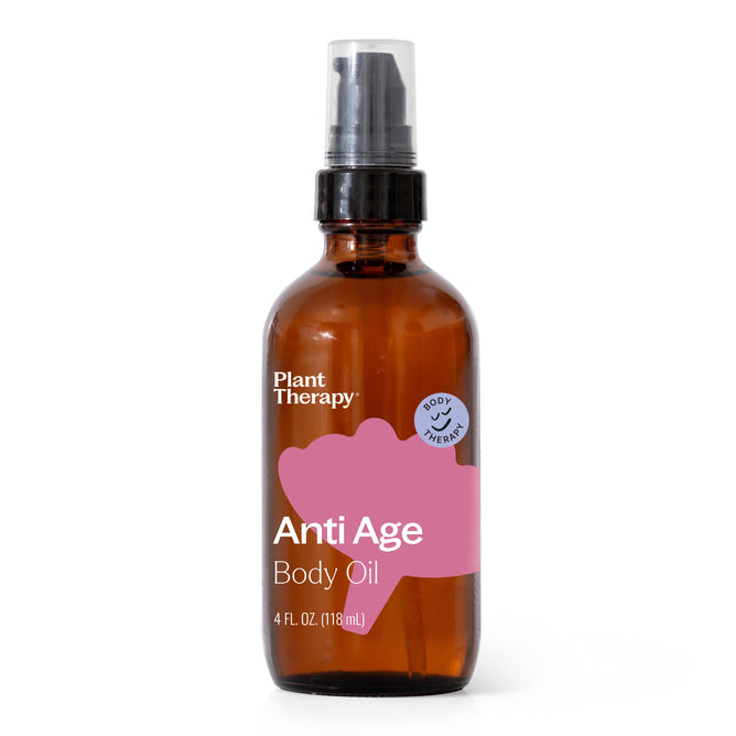 A 4 fl oz (118 ml) brown glass bottle of Plant Therapy Anti Age Body Oil, an essential oil blend for youthful, glowing skin. It features a spray top and a pink and white label with the product name and a small blue circle for the brand.