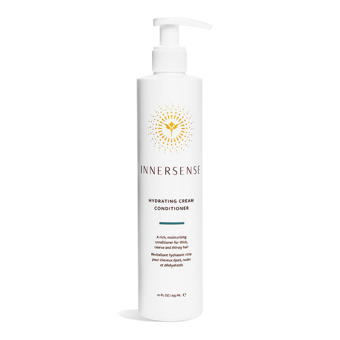 A white bottle of Innersense Organic Beautys Hydrating Cream Conditioner with a pump top stands elegantly on a white background, featuring a golden emblem on its label that highlights its organic ingredients.