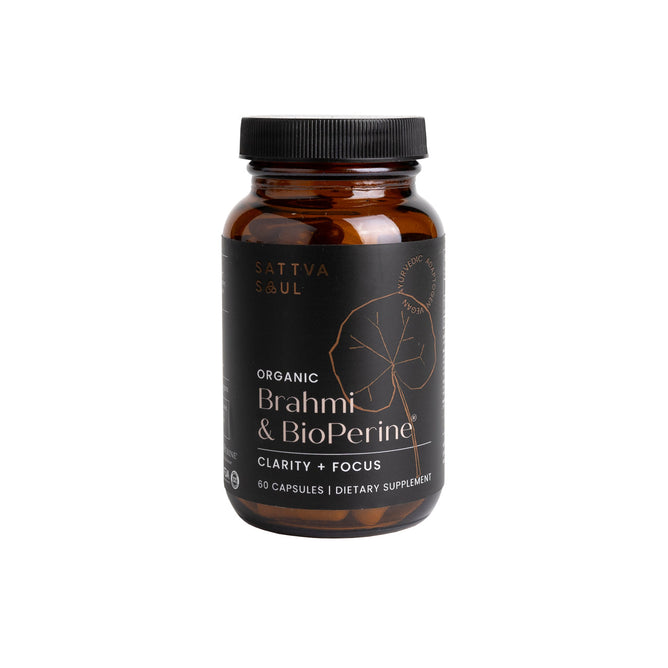 A brown bottle labeled Organic Brahmi & Bioperine - For Clarity and Focus by Sattva Soul is set against a white background. It contains 60 capsules to support clarity and focus. The label, adorned with a simple leaf illustration, embodies Ayurvedic science principles.