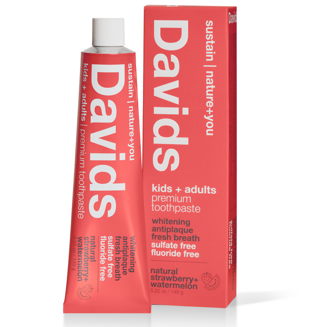 A pink tube of Davids Kids+Adults Premium Toothpaste comes with a matching box. Its fluoride-free, suitable for all ages, and offers strawberry and watermelon flavor. It claims natural whitening and antiplaque benefits, free from sulfates.