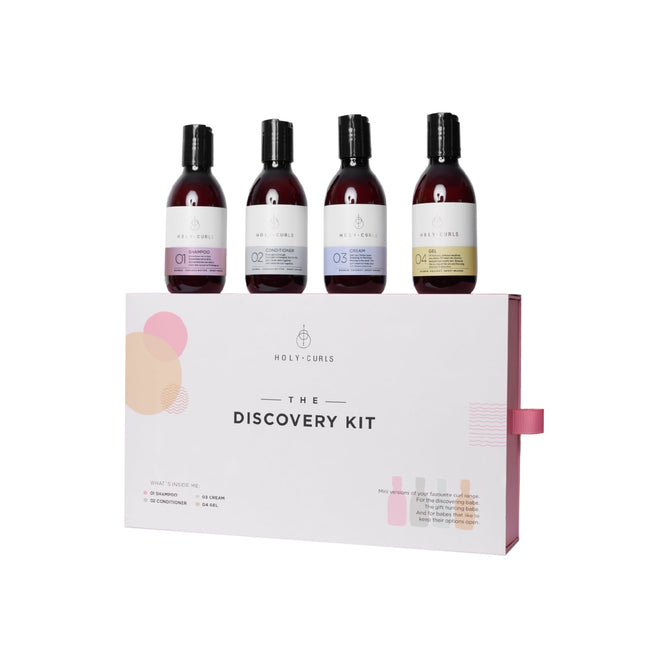 The Discovery Kit from Holy Curls includes four distinct hair care bottles labeled 1 to 4. Each has a dark cap and unique colored label, representing the diverse products designed for your curls, displayed on a white background atop a box labeled with the kits name.