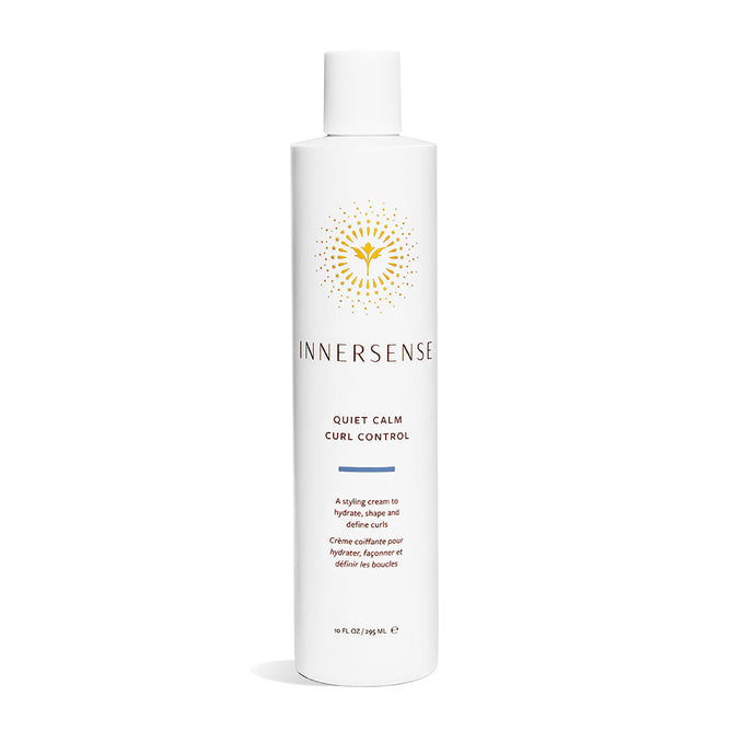 A white bottle of Quiet Calm Curl Control by Innersense Organic Beauty is shown against a plain background, featuring a yellow logo and text. Its described as the perfect solution to hydrate curls and effortlessly tame frizz.