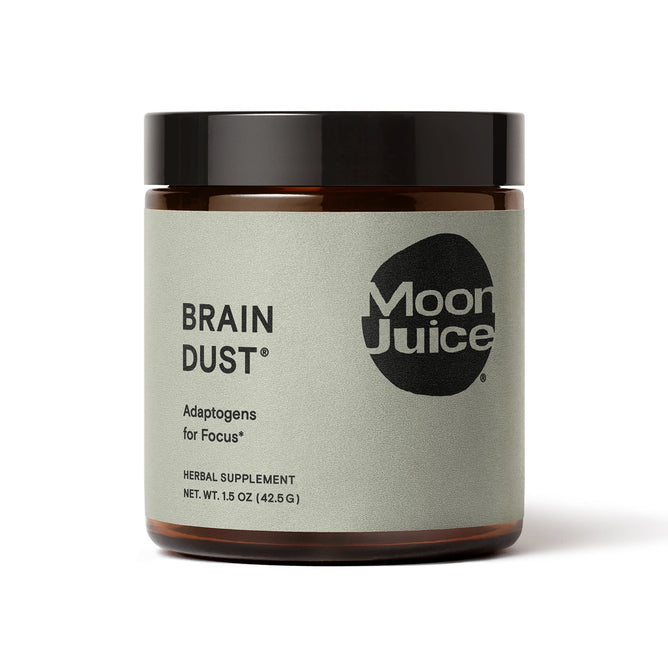 Moon Juice Brain Dust, an adaptogen blend for mental stamina, alertness, and concentration, comes in a jar with a light gray label featuring black text and a round logo. Its labeled as an herbal supplement with a net weight of 1.5 oz (42.5 g).