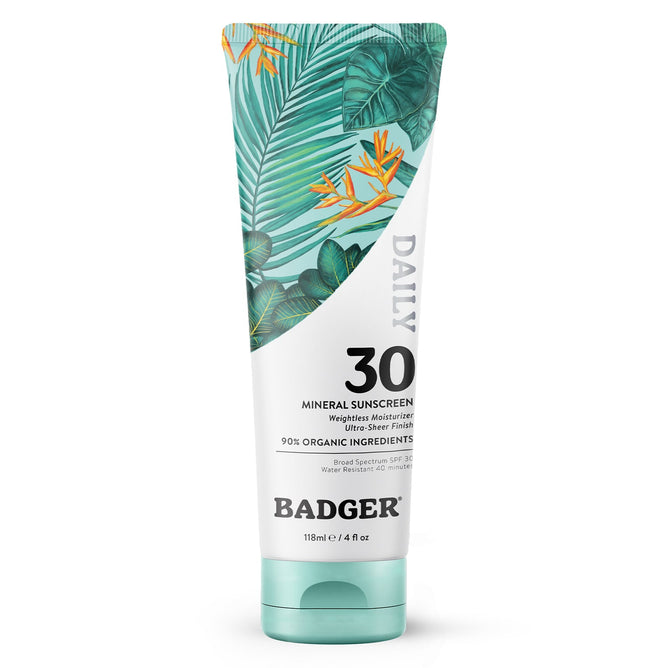 A 118 ml tube of Badger Balm Daily Mineral Sunscreen - SPF 30 features green tropical leaves and orange flowers, emphasizes 90% organic ingredients, and acts as both a sunscreen and moisturizer to ensure your skin is protected and nourished.