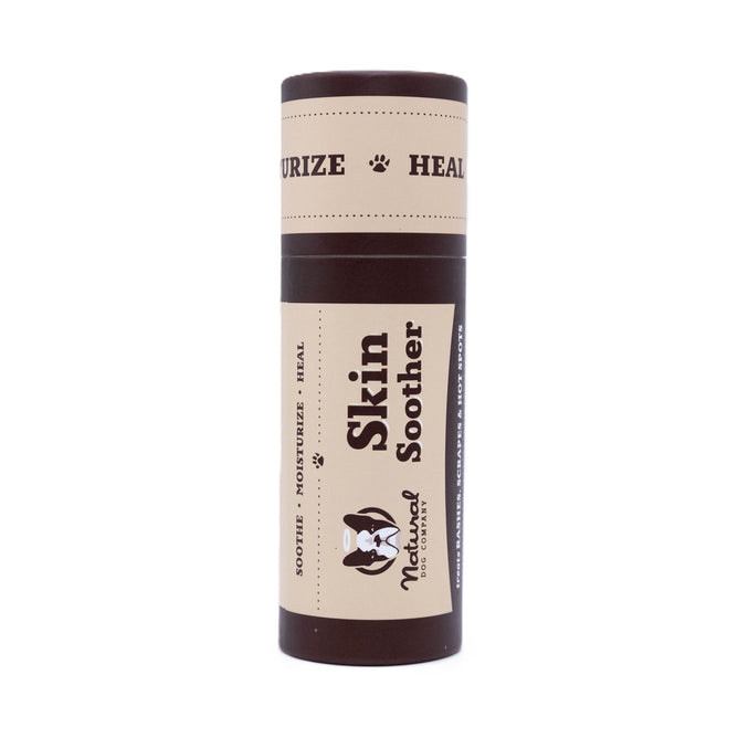 Skin Soother by Natural Dog Company is a dog balm in a cylindrical container. The cream label with brown text and paw prints says Moisturize Heal, highlighting its purpose to soothe and rejuvenate your dogs skin naturally.