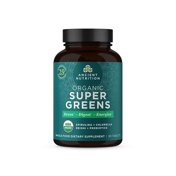 A dark bottle of Ancient Nutritions Organic Super Greens dietary supplement features a green label promoting regenerative superfoods for detox, digestion, and energy. It contains spirulina, chlorella, reishi, and probiotics for digestive health. USDA Organic certified. 90 tablets.
