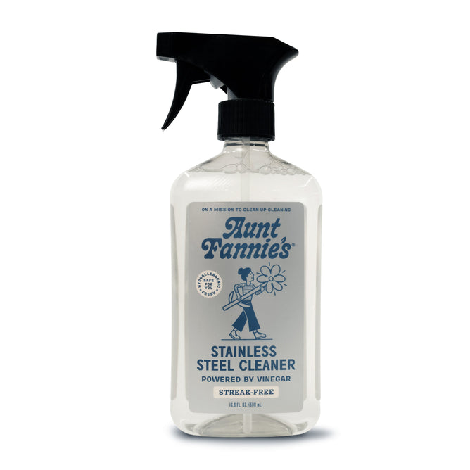 Aunt Fannies Stainless Steel Cleaner spray bottle has a vintage-style label of a person cleaning and a sleek black nozzle. It promises Vinegar Powered performance for non-abrasive, streak-free, gleaming surfaces.