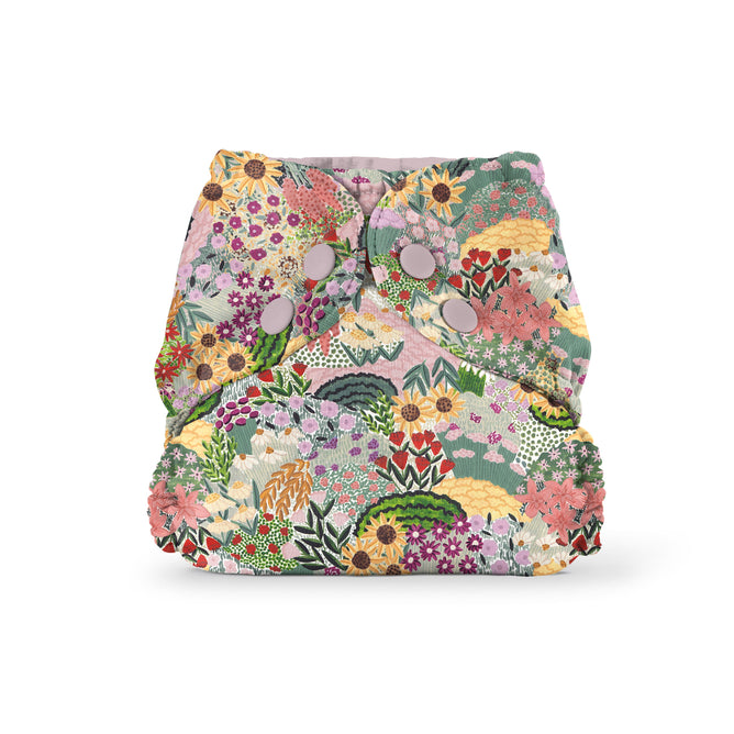 Esembly Babys Outer Diaper Cover + Swim Diaper, crafted from 100% OEKO-TEX Certified Recycled Fabric in Size 1, boasts a vibrant floral pattern with sunflowers, daisies, and more in red, pink, yellow, and green hues. This charming reusable diaper includes front button fasteners.