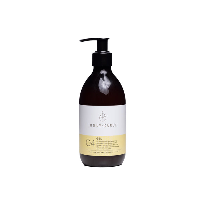 A dark brown pump bottle labeled Gel by Holy Curls features a white and yellow label. Infused with coconut oil, it tames, defines, and adds shine to curls against a plain white background.