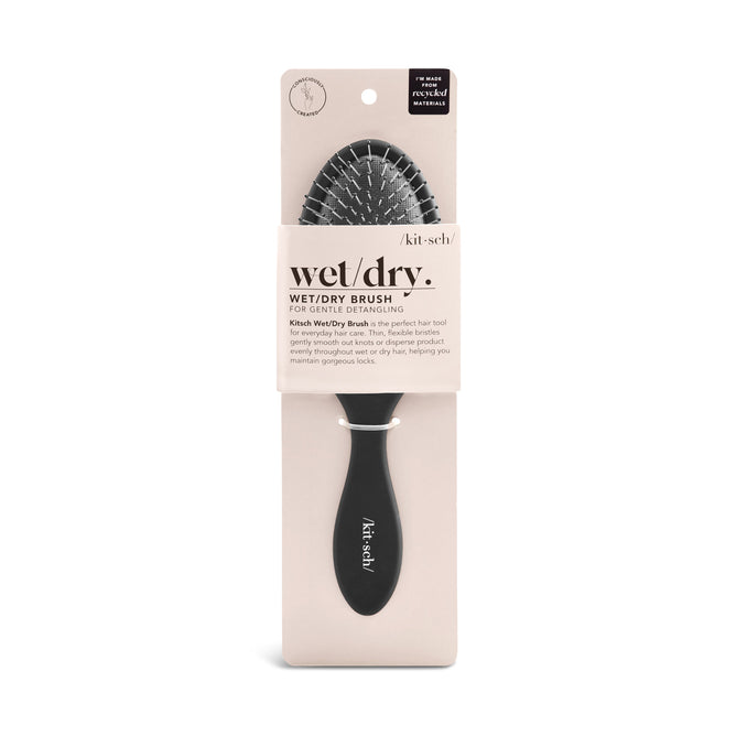 The Consciously Created Wet/Dry Brush by Kitsch features white flexible bristles in beige packaging labeled wet/dry brush. This gentle detangler is suitable for wet or dry hair and kind to delicate strands, with the brand name on the handle.