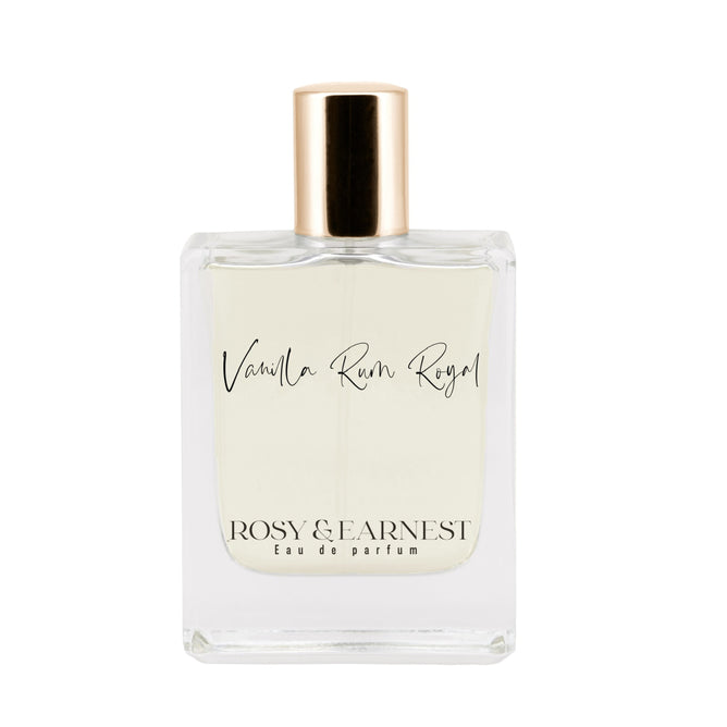 The clear perfume bottle with a gold cap is elegantly labeled as Vanilla Rum Royal by Rosy & Earnest Eau de Parfum, containing a light-colored liquid that promises a delightful gourmand fragrance experience.