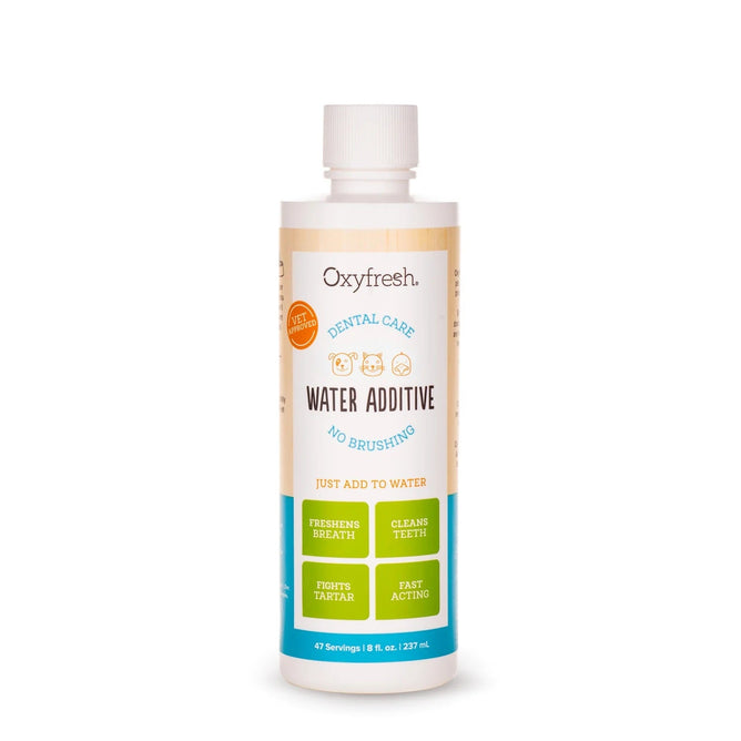 An 8 fl. oz. white bottle of Oxyfresh Pet Water Additive is displayed, featuring a label with pet images and claims like No Brushing, Freshens Breath, Cleans Teeth, Fights Tartar and Plaque, and Fast Acting to address bad pet breath.