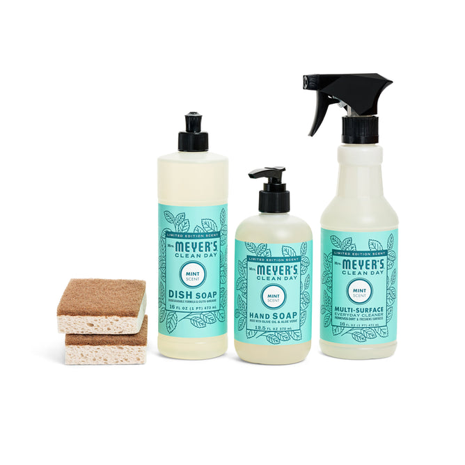 The Blooming Buds Scrubbing Set by Mrs. Meyers includes a dish soap bottle, hand soap pump, and a Meyers Clean Day Multi-Surface Cleaner in refreshing mint scent. Two stacked sponges are included for convenience.