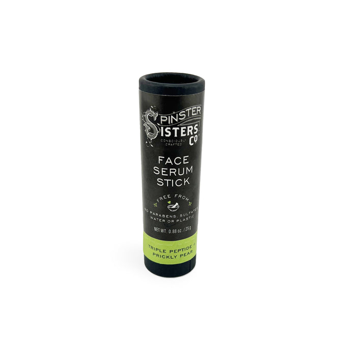 A black cylindrical Spinster Sisters Co. Face Serum Stick with Triple Peptide and Prickly Pear is labeled on a green band at its base. It contains copper tripeptides and is free of parabens, sulfates, water, and phthalates. Net weight: 0.88 oz/25 g—perfect for skin revitalization.