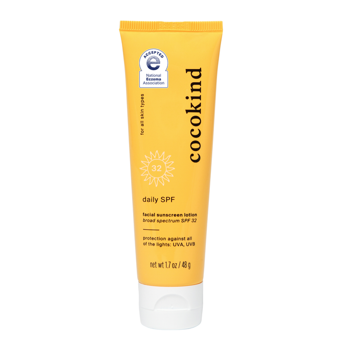 The Cocokind Daily Facial Sunscreen Lotion - SPF 32 comes in a yellow tube, features a National Eczema Association seal, and is formulated with zinc oxide. This mineral sunscreen suits all skin types, offering 1.7 oz (48g) of broad-spectrum UV protection.