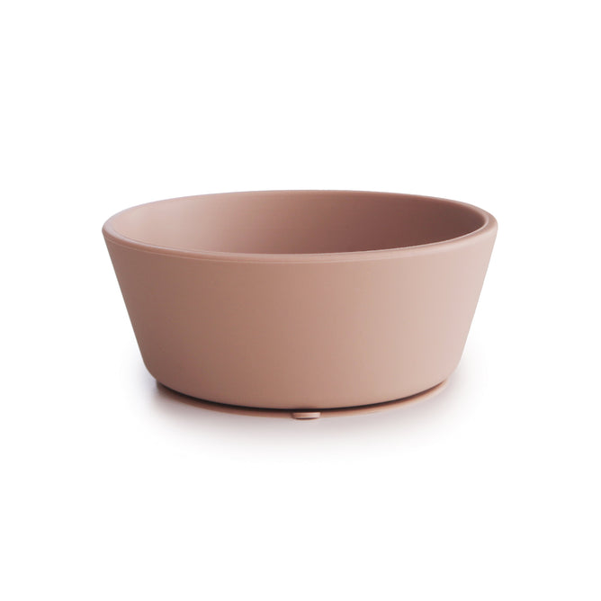 The mushie Silicone Suction Bowl is a simple, round, light brown bowl with smooth sides and a matte finish, made from BPA-free, food-grade silicone. Safe, non-toxic design shown on a white background.