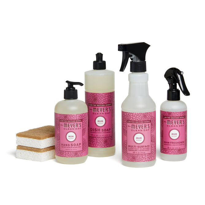 Four Grove Collaborative fall-bakers-bundle products in pink and white packaging are shown: hand soap, dish soap, multi-surface spray, and room freshener. Two sponges sit to the left of the bottles.