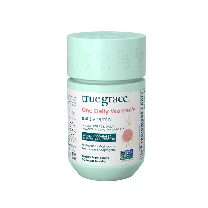 A mint-green bottle labeled True Grace One Daily Womens Multivitamin offers immune, energy, and beauty support with whole food-based fermented nutrients and Coenzyme B Vitamins. It includes 30 vegan tablets, features certifications on the label, and suggests the inclusion of organic mushrooms.