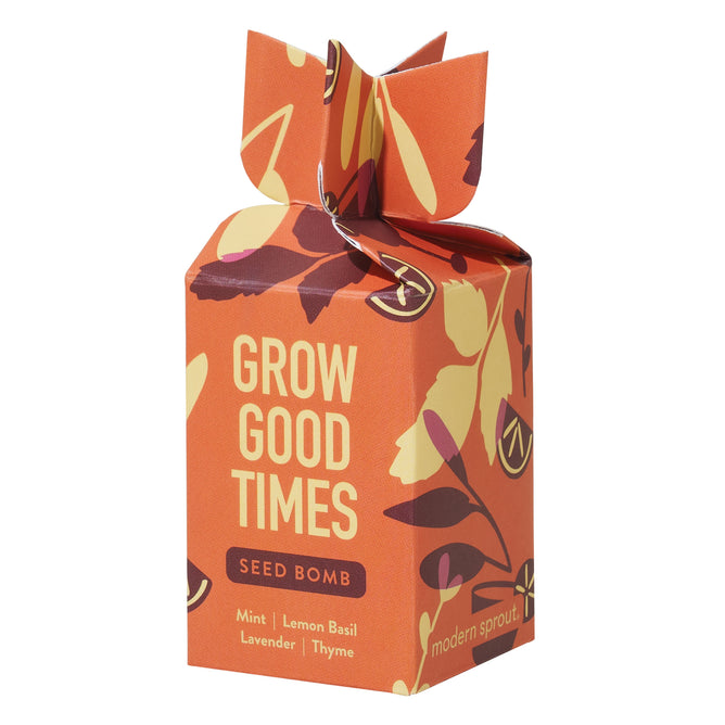 Orange box with leaf patterns, labeled Grow Good Times Seed Bomb, contains organic mint, lemon basil, lavender, and thyme seeds. Gift-like design with folded top features Modern Sprout branding at bottom.