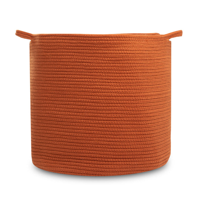 A large, round, orange woven rope storage basket by Natemia features two small side handles. Made from organic cotton, it has a textured look with horizontal patterns. Set against a plain white background, it is perfect as a chic nursery organizer.
