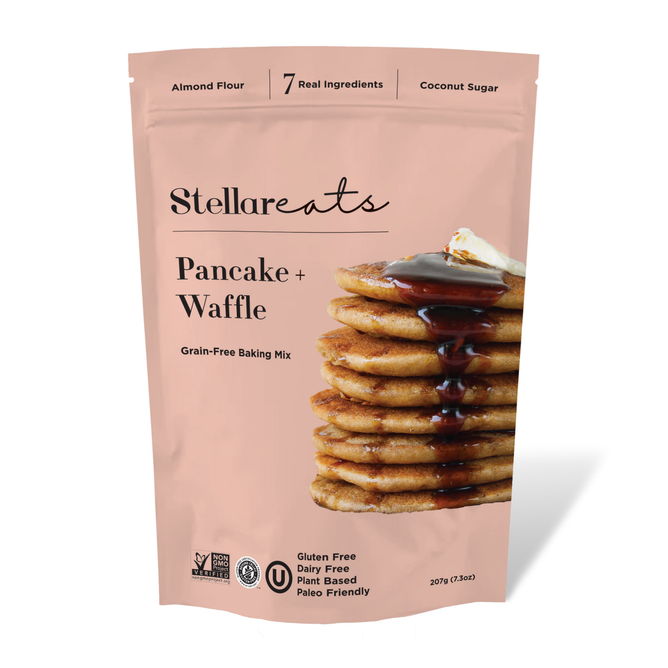 A pink Stellar Eats Pancake + Waffle Mix package features a pancake stack with butter and syrup, highlighting almond flour, coconut sugar, and its gluten-free, Paleo-friendly benefits.