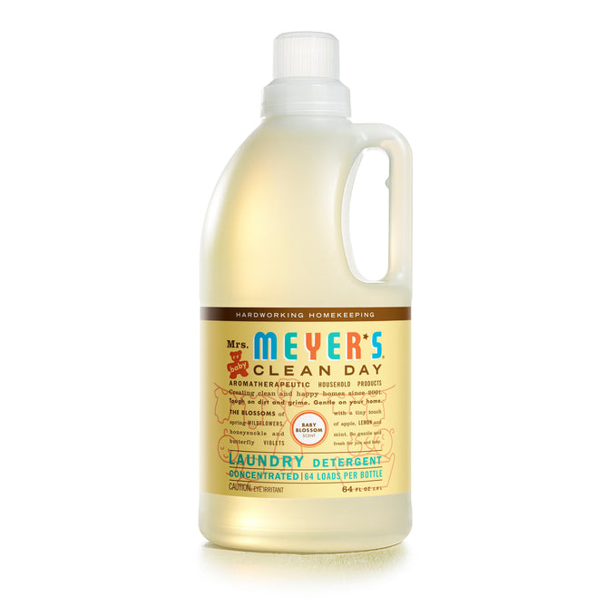 The translucent bottle of Mrs. Meyers Baby Laundry Detergent features a light pink label, offers natural ingredients and a concentrated formula for 64 loads, providing gentle care specifically for baby laundry needs.