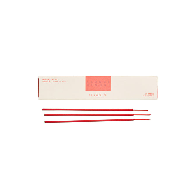 A sleek white box with P.F. Candle Co. in red text showcases three red HI-FI Incense Sticks beautifully arranged, labeled as Sandalwood Rose, embodying their signature scents and minimalist style with hints of aromatic greenery in the small print.