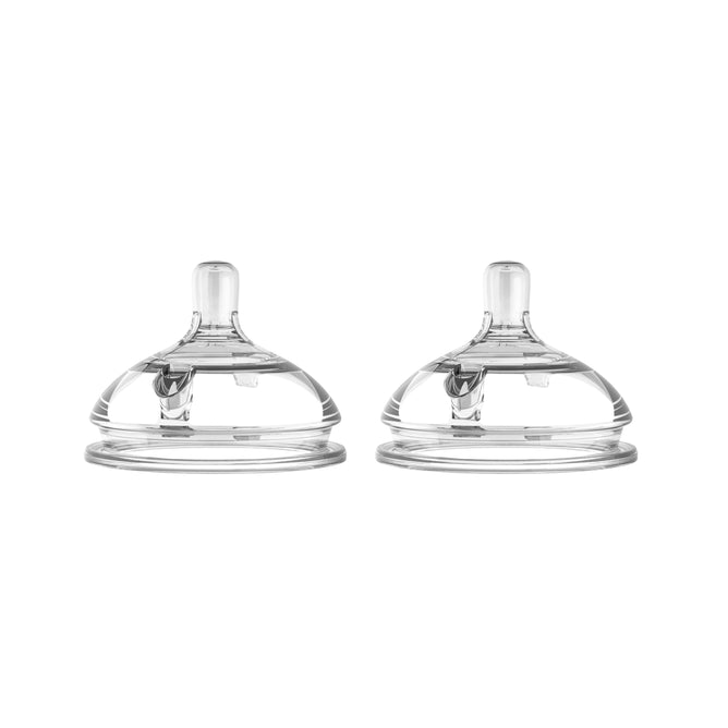 Two transparent Comotomo Replacement Nipples, Fast Flow, compatible with Comotomo Baby Bottles, are side by side on a white background. Their wide-neck design and anti-colic vents enhance feeding comfort, featuring a rounded base that tapers to a smaller top opening.