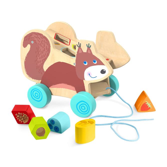 The Squirrel Pull Along Toy Sorting Box by HABA is a wooden squirrel-shaped toy with blue wheels, featuring vibrant geometric shapes in yellow, red, blue, and orange. It aids development with shape-matching holes on its back and includes a pull string. Made from sustainably sourced materials.