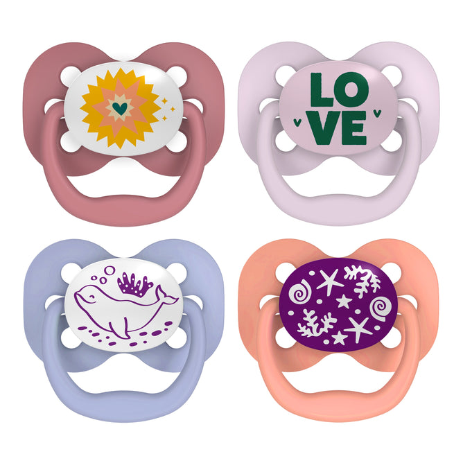 Explore Dr. Browns Advantage Glow-in-the-Dark Baby Pacifiers, Stage 1. Features: top left - orange sun/heart on pink, top right - green LOVE on white/purple, bottom left - pink whale on blue, bottom right - snowflakes/swirl on purple with orange silicone bulbs. Fully symmetrical soother included.