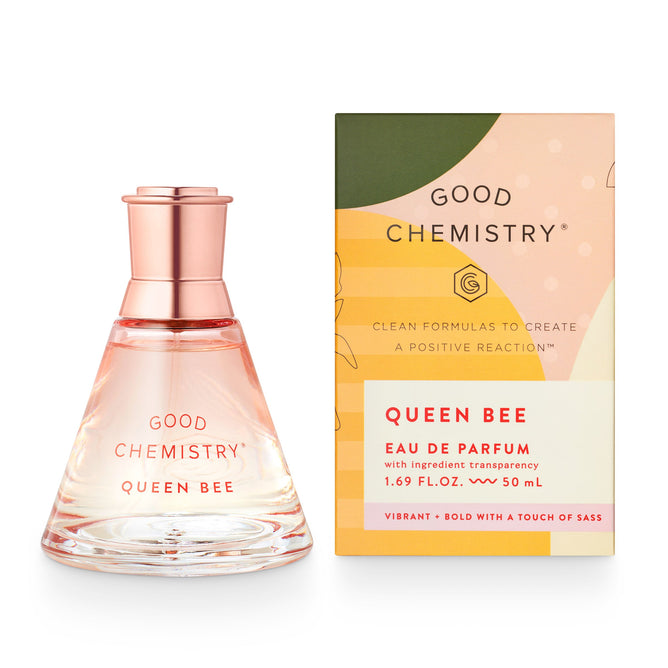 A Queen Bee eau de parfum bottle by Good Chemistry features a pink cap and conical glass design. The green and peach box reads Vibrant + Bold With a Touch of Sass. This vegan, cruelty-free fragrance embodies ethical elegance.